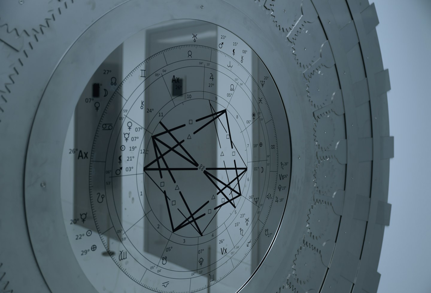 Astrology chart layered over a metallic gear mechanism.