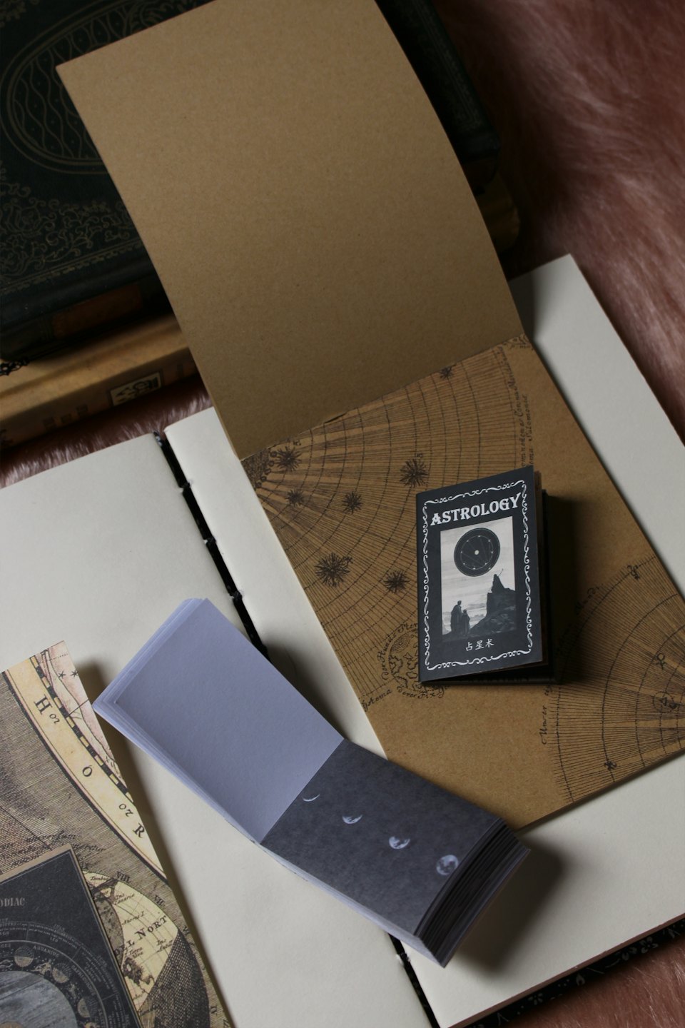 Open journal with astrology booklet and sticky notes on celestial charts.